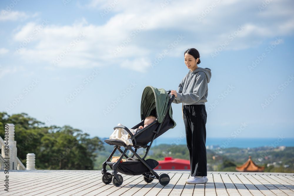 Mother pushing baby stroller with scenic view