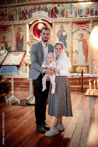 a family with children in an Orthodox Christian church or temple are praying or have come to the sacrament of baptism, believers in a holy place, introducing children to the faith