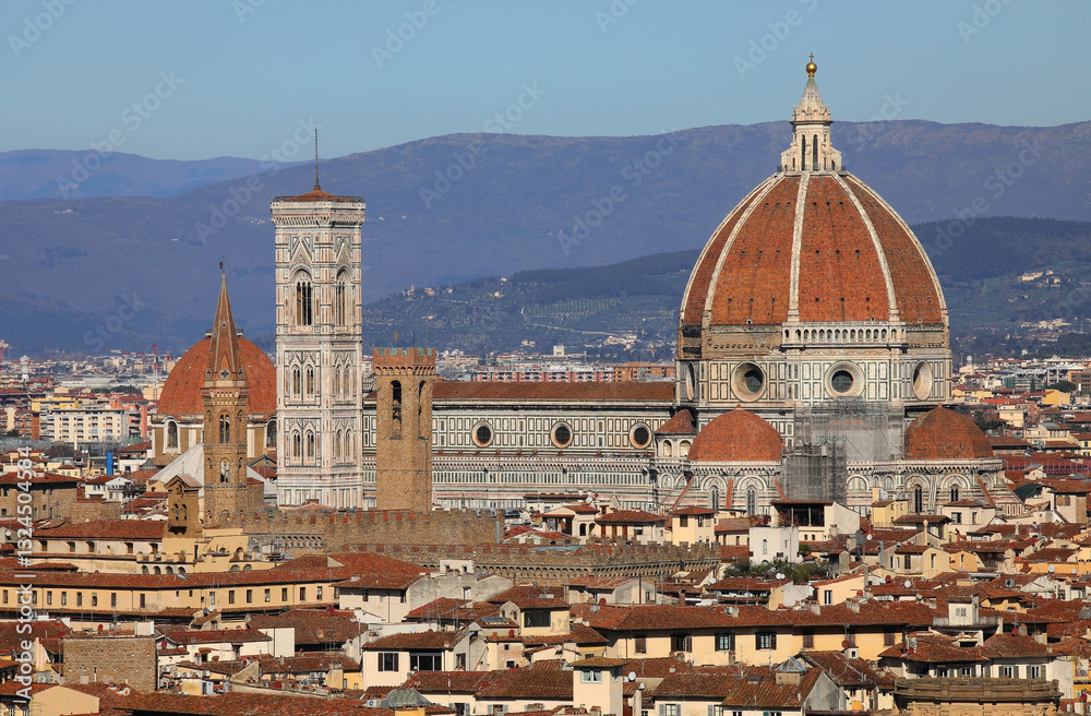 Fototapeta premium view of florence cathedral with the tall bell tower by artist giotto and the grand dome by architect brunelleschi with the tuscan hills in the background