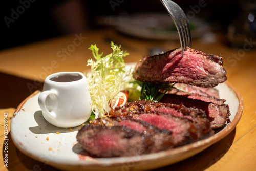 Wallpaper Mural A fork on medium rare wagyu meat served on plate with sauce and vegetable Torontodigital.ca