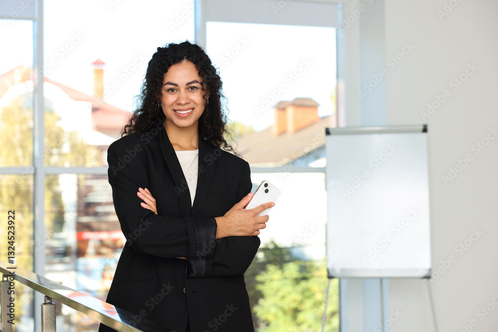Portrait of young woman with phone wearing stylish suit indoors. Space for text Portrait of young woman with phone wearing stylish suit indoors. Space for text
