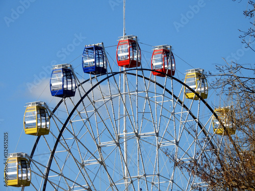 Ferries wheel in the park with red, yellow, blue cabins