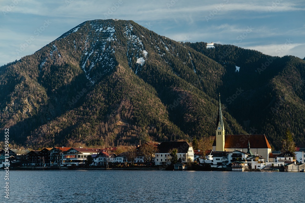 Lakeside town with a church and mountains in the background. Natural landscape, outdoor scene, daytime. Lakeside town with a church and mountains in the background. Natural landscape, outdoor scene, daytime.