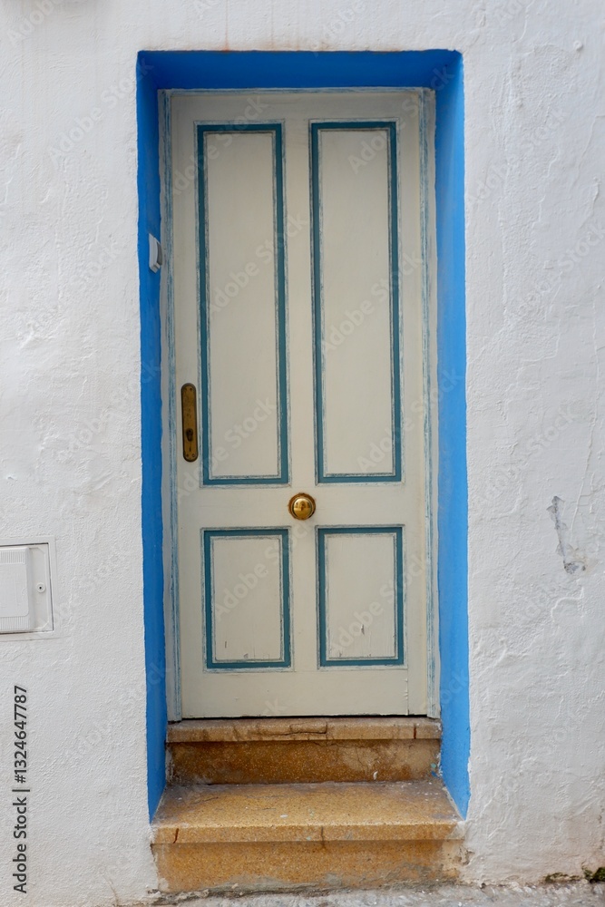 Fototapeta premium White weathered door with blue frame in Peniscola, Spain