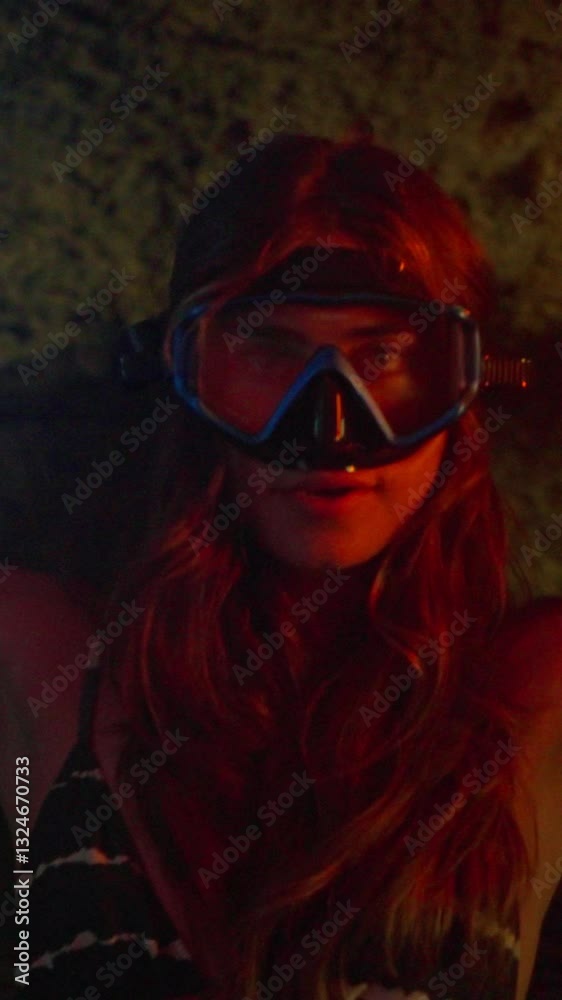 Female model wearing a diving mask dancing inside a cave with led lights and the a limestone wall in the background, the video was filmed inside a cenote cave in Tulum, Mexico Female model wearing a diving mask dancing inside a cave with led lights and the a limestone wall in the background, the video was filmed inside a cenote cave in Tulum, Mexico