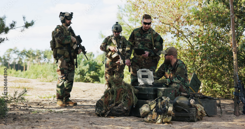 A group of servicemen prepares for action, defending territory, checking maps, entering data on the computer, and sending information to base while gearing up for an expedition in the forest. A group of servicemen prepares for action, defending territory, checking maps, entering data on the computer, and sending information to base while gearing up for an expedition in the forest.