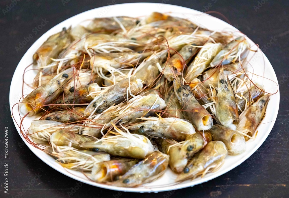 Fresh shrimps on white round plate isolated in selective focus. Shrimp head Fresh shrimps on white round plate isolated in selective focus. Shrimp head