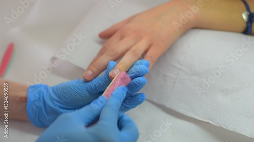 A manicurist performing a Japanese manicure on a client
