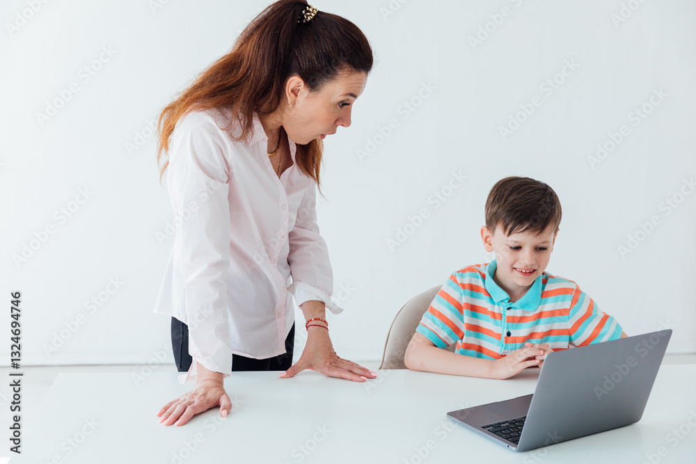 Female teacher helping boy on laptop to play Female teacher helping boy on laptop to play