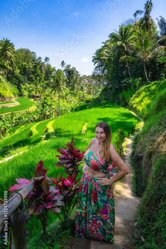 Obraz na płótnie A confident woman stands proudly in a vibrant floral dress amid the stunning rice terraces of Bali, completely surrounded by lush nature and a sense of tranquility, Ubud, Indonesia w salonie