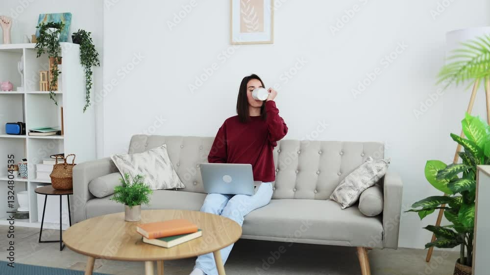 Young woman relaxing at home with laptop and coffee Young woman relaxing at home with laptop and coffee