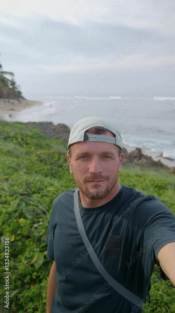 Man recording himself in selfie mode on tropical beach shore near ocean. Man recording himself in selfie mode on tropical beach shore near ocean.