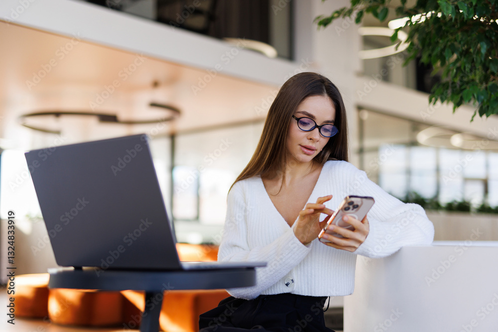Young smiling business woman using smartphone in modern office Young smiling business woman using smartphone in modern office