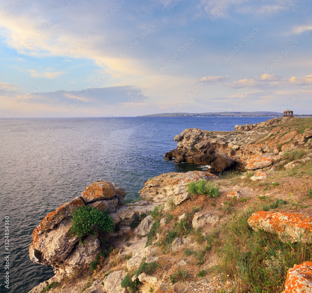Rocky summer coastline and cape with pavilion