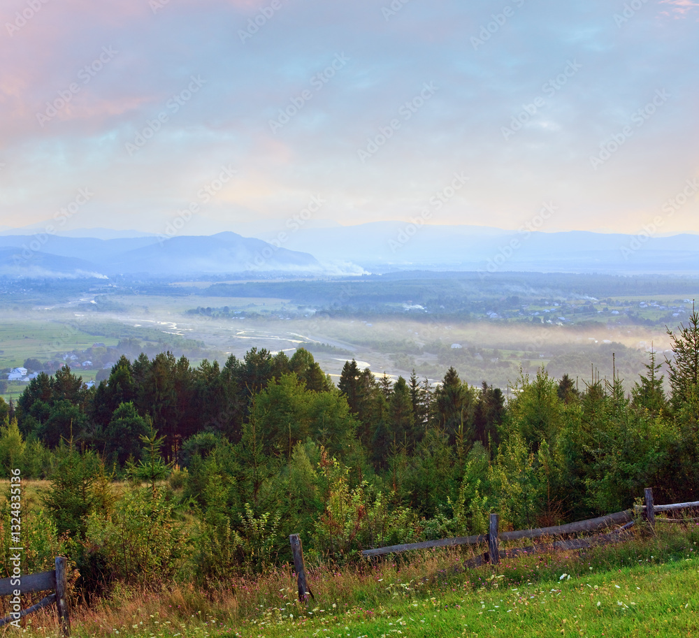 countryside landscape with wooden fence and mountain behind