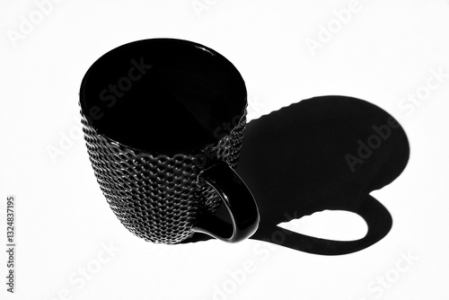 Black and white still life. Shadow of empty cup on table