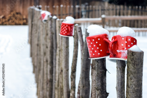 Obraz na płótnie Red pot with white dots on wooden fence in snowy rural country w salonie