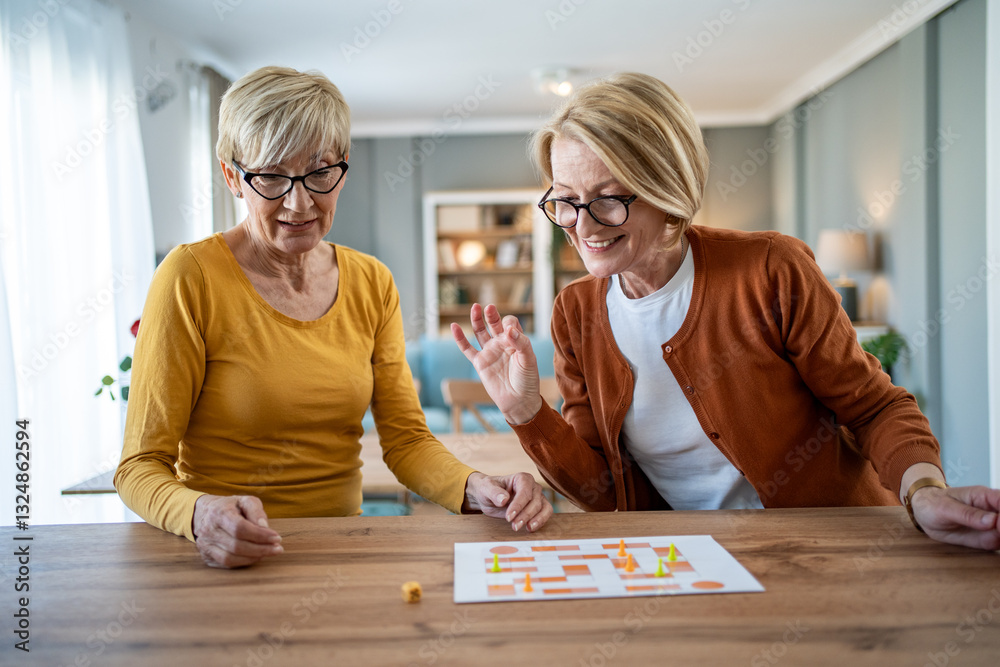 Two senior women playing board game at home, enjoying their time together Two senior women playing board game at home, enjoying their time together