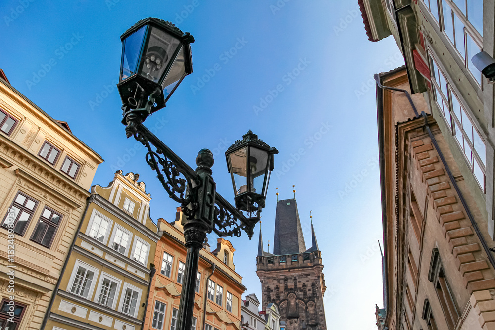 A street scene in Prague Czech Republic with a tall building in the background and two street lamps
