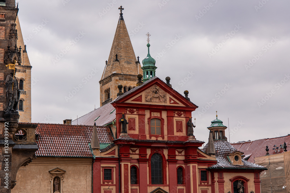 Fototapeta premium St. George's Basilica rising above Prague roofs on cloudy day