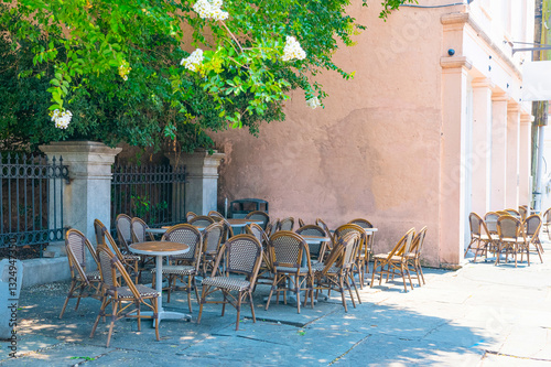 Fototapeta Naklejka Na Ścianę i Meble -  Tables and chairs of a street cafe in a small town on a summer day.
