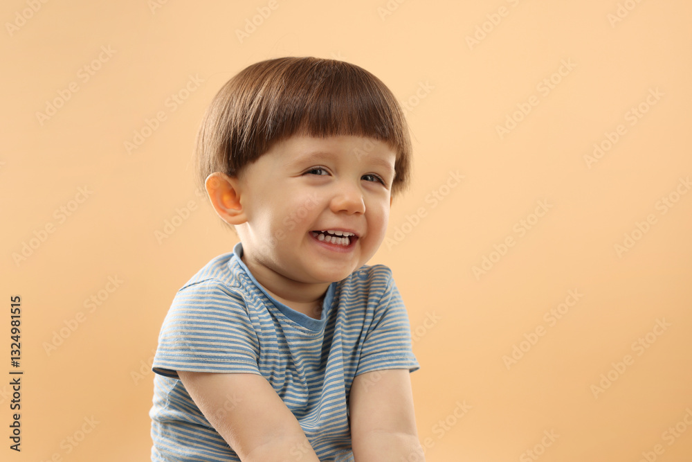 Portrait of happy little boy on beige background. Space for text Portrait of happy little boy on beige background. Space for text