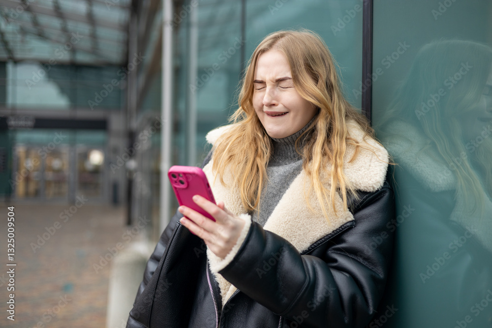 Sad 30s women desperately looking at smartphone screen outdoors. Young female receives bad news on the phone. High quality photo.