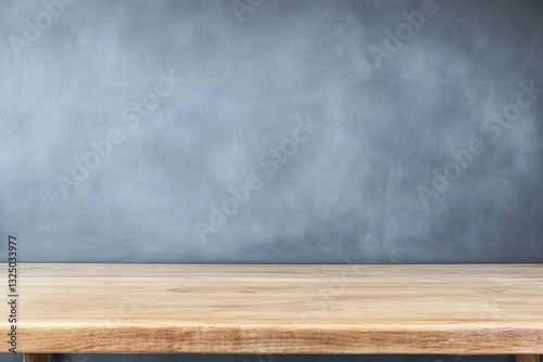 Empty light brown wooden table in front of a light gray textured wall