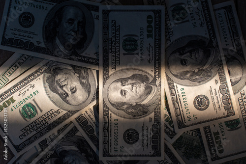 Stack of US hundred dollar bills with dramatic lighting and shadows. Concept of wealth, financial power, black market, cash flow, economic growth, fortune, banking security, and currency investment.