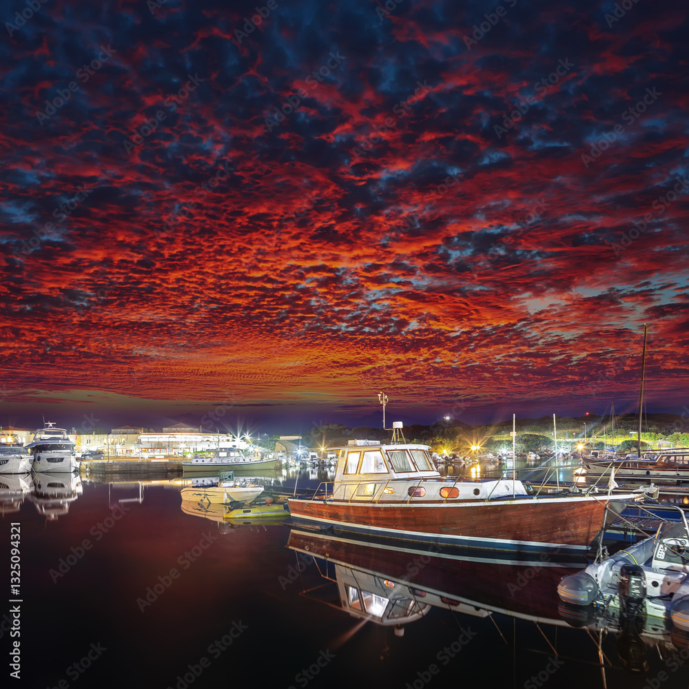 Remarkable sunset view on boats in beautiful marina of Villasimius.