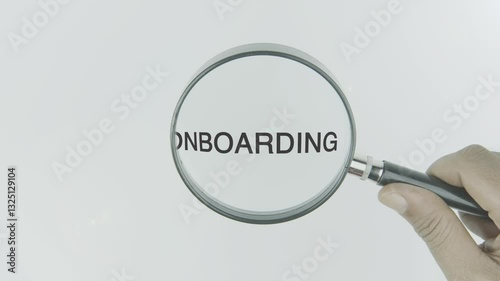 Onboarding text or word highlighted by a magnifying glass in a hand on a white background, symbolizing focus on the process of integrating new employees or users into a system or organization