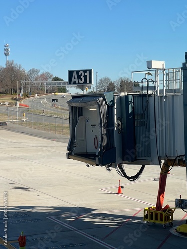 An unattached jet bridge connector extending from an airport terminal gate