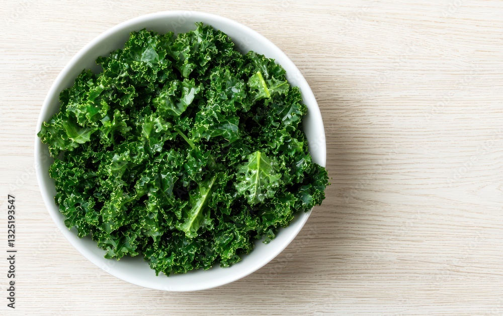 Fresh green kale leaves in a white bowl on a light wooden background. Overhead view. Healthy eating concept Fresh green kale leaves in a white bowl on a light wooden background. Overhead view. Healthy eating concept