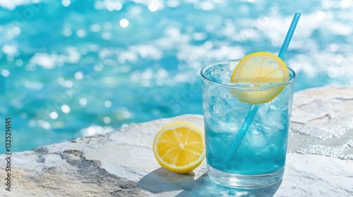 A refreshing blue drink garnished with lemon sits on a stone ledge by a sparkling pool, Ideal for summer promotions, beverage advertisements, or lifestyle blogs focusing on relaxation and enjoyment,