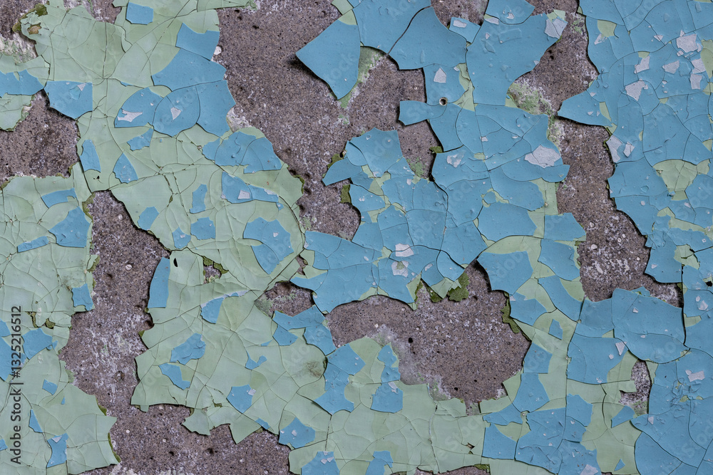 Peeling paint on the wall. Old concrete wall with cracked flaking paint. Weathered rough painted surface with patterns of cracks and peeling. High resolution texture for background and design. Closeup