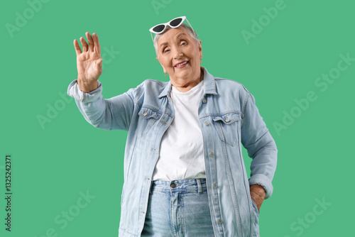 Senior woman waving hand on...
