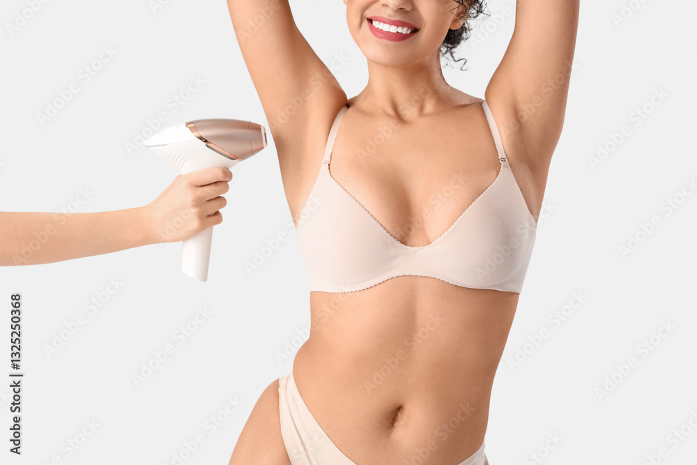 Φωτογραφία Young woman in underwear and hand of beautician with photoepilator on white back