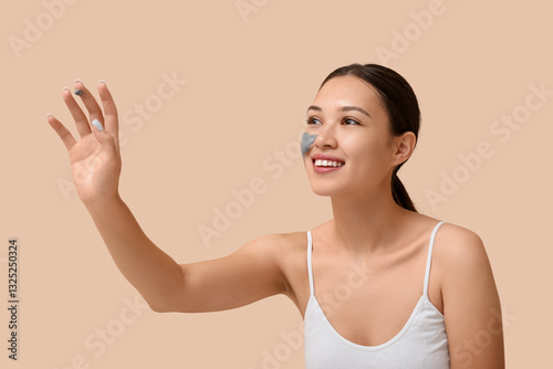Young woman with clay mask ...