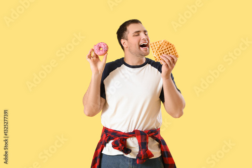 Young man with doughnut and...