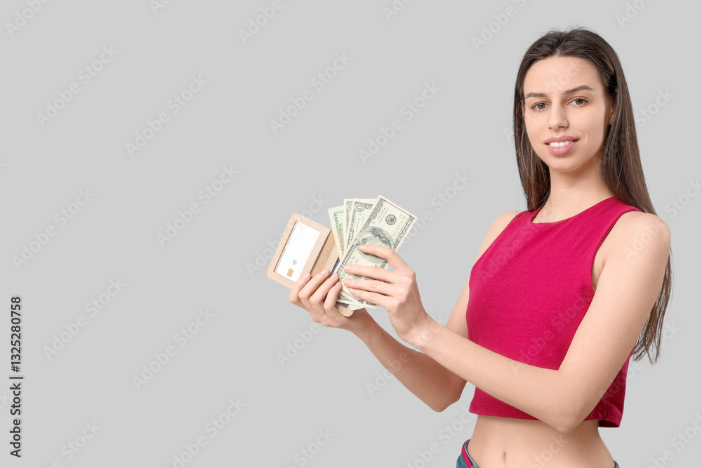 Beautiful young woman with cash and credit card holder on grey background Beautiful young woman with cash and credit card holder on grey background