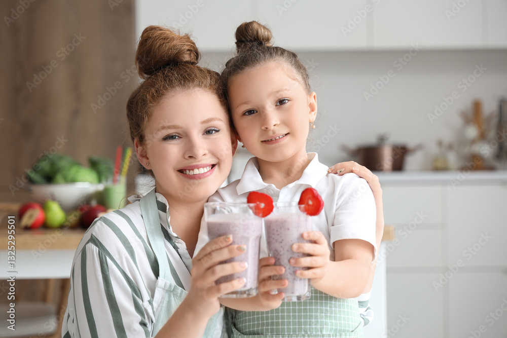 Mother and little daughter with glasses of strawberry smoothie in kitchen Mother and little daughter with glasses of strawberry smoothie in kitchen