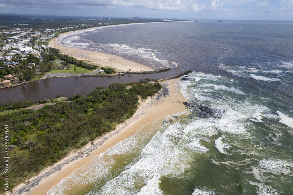 Aerial views of muddy waters from Cudgen Creek after Cyclone Alfred flowing in to the sea at Kingscliff headland seawall along the east coast of New South Wales, Australia Aerial views of muddy waters from Cudgen Creek after Cyclone Alfred flowing in to the sea at Kingscliff headland seawall along the east coast of New South Wales, Australia