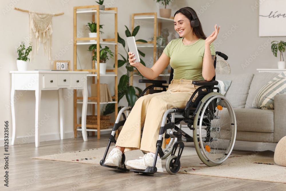 Beautiful young woman in wheelchair with headphones using tablet computer at home Beautiful young woman in wheelchair with headphones using tablet computer at home