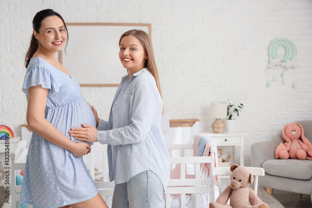 Fototapeta premium Young pregnant lesbian couple in bedroom