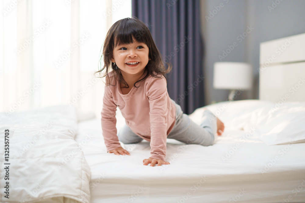 cheerful toddler girl playing and laughing on bed cheerful toddler girl playing and laughing on bed