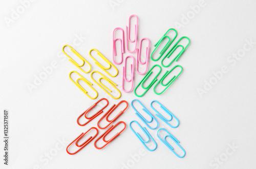 Colorful paper clips on light background, flat lay