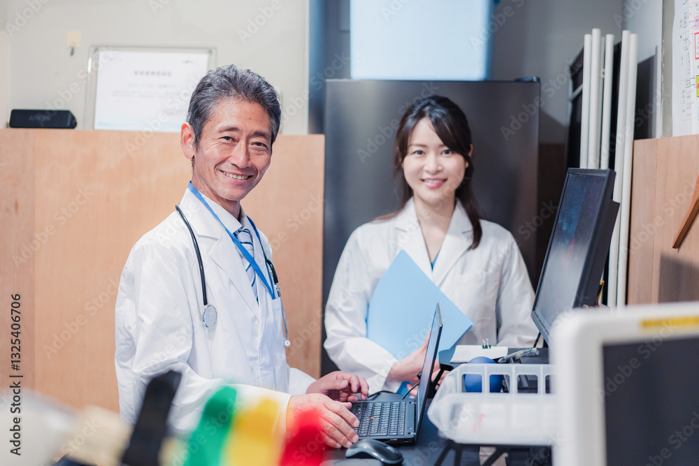 Fototapeta premium ナースステーションで打ち合わせをする医療従事者たち