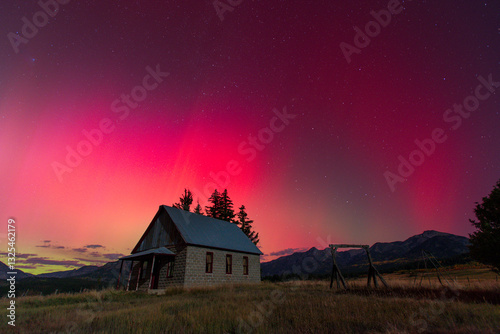 Aurora Borealis behind abandoned schoolhouse
