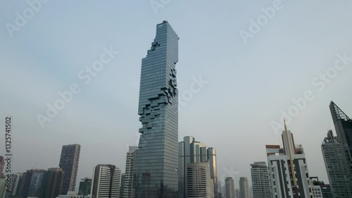 Drone Shot of Mahanakhon Tower skywalk, rooftop, in Bangkok, Silom area, business district, downtown. Circle around a skyscraper in Thailand.