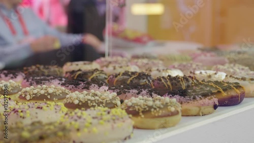 Large collection of donuts displayed on the counter under the glass